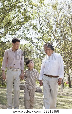 Multi-generational family holding hands and walking