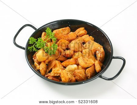portion of fried pork greaves served in a black pan