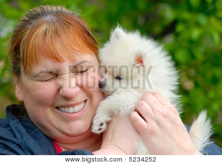 Femme tenant un Adorable chiot Pomeranian blanc