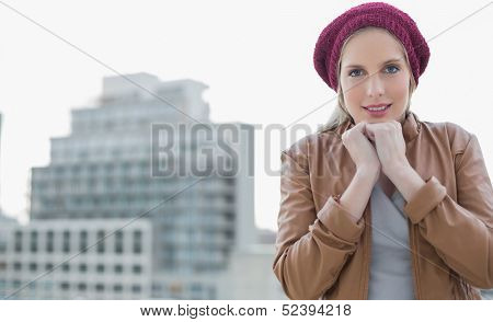 Shivering casual blonde posing outdoors on urban background