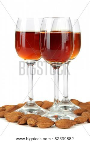 Glasses of amaretto liquor and roasted almonds, isolated on white