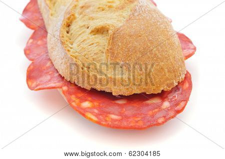 closeup of a spanish bocadillo de chorizo, a chorizo sandwich, on a white background