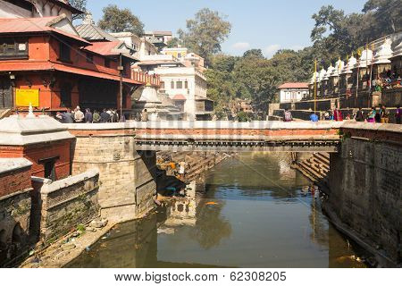 KATHMANDU, NEPAL - DEC 3, 2013: Unidentified local people during the cremation ceremony along the holy Bagmati River in Bhasmeshvar Ghat at Pashupatinath temple in Kathmandu.