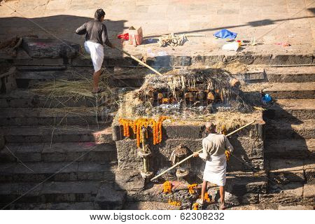 KATHMANDU, NEPAL - DEC 3, 2013: Unidentified local people during the cremation ceremony along the holy Bagmati River in Bhasmeshvar Ghat at Pashupatinath temple in Kathmandu.