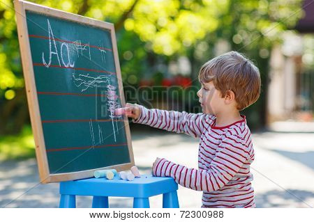 Little Boy At Blackboard Practicing Mathematics