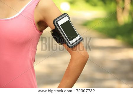 Runner athlete listening to music from smart phone mp3 player smart phone armband.