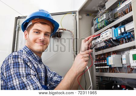 Technician Examining Fusebox With Multimeter Probe