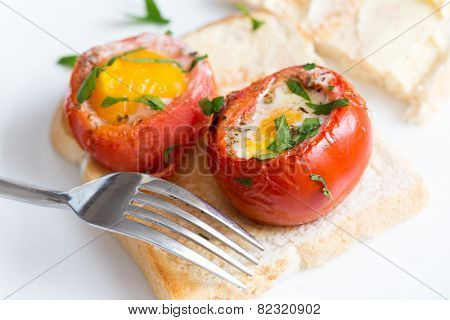 Baked, de-seeded tomatoes filled with an egg and finished in the oven, served on toast with a parsley garnish. This Italian dish is uova al piatto con pomodori