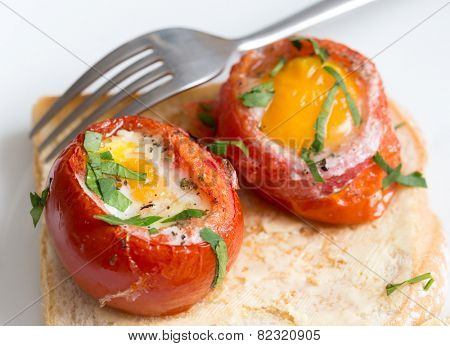 Baked, de-seeded tomatoes filled with an egg and finished in the oven, served on toast with a parsley garnish. This Italian dish is uova al piatto con pomodori