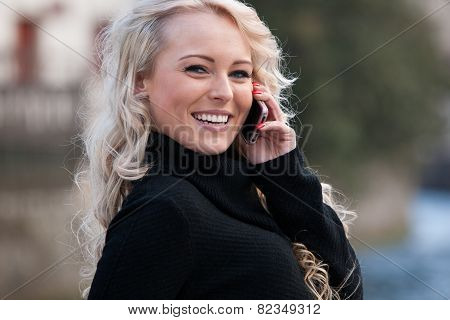 Blonde Woman Talking On Her Mobile Phone Smiling