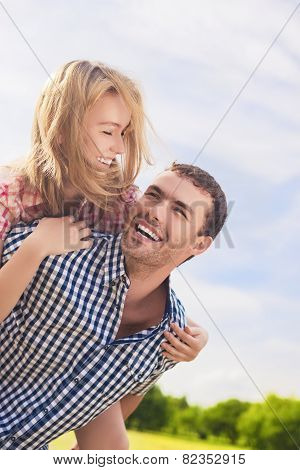 Portrait Of Happy And Cheerful Young Caucasian Couple Piggybacking Outdoors.summer Vacations And You