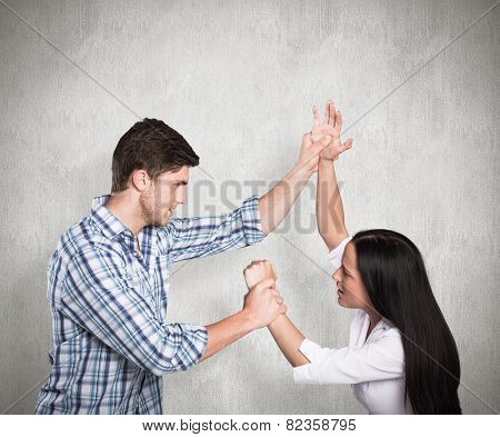 Aggressive man overpowering his girlfriend against weathered surface