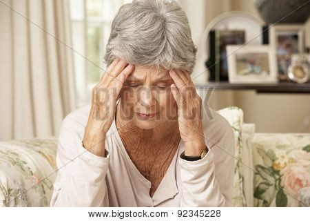 Unhappy Retired Senior Woman Sitting On Sofa At Home