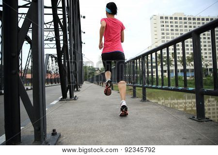 Runner athlete running on iron bridge. woman fitness jogging workout wellness concept.