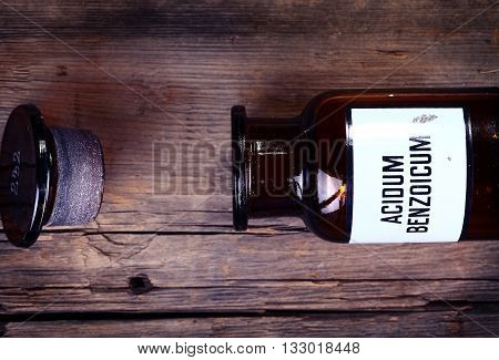 Old chemical bottle with label on wooden background