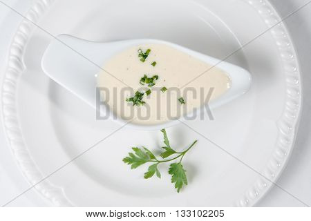 Tasty Bechamel sauce or white sauce with fresh greenery.