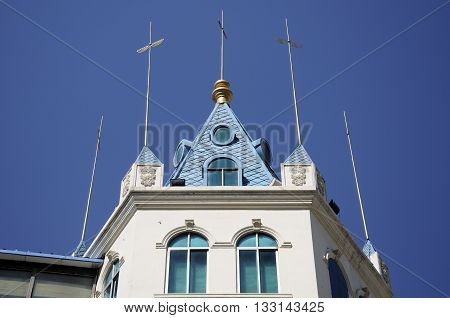 Gold lightning rods on top of a building against a blue sky on Zhongyang street in harbin China within Heilongjiang province.