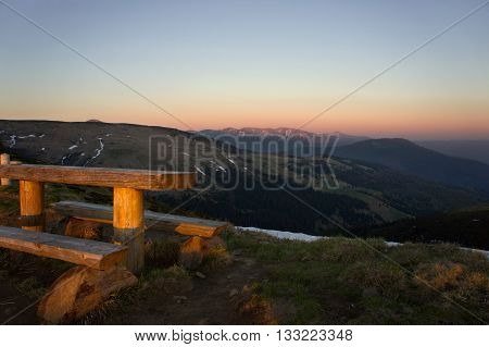 Outdoor bench in a nice mountain area. Sunset landscape