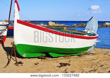 closeup of an old fishing boat stranded on the Platja de les Barques beach in Calella de Palafrugell, Costa Brava, Catalonia, Spain