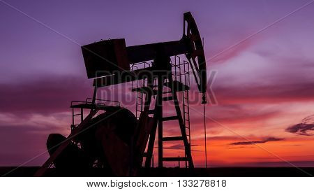 Sunset sky with profiled oil well, in remote European oil and gas field