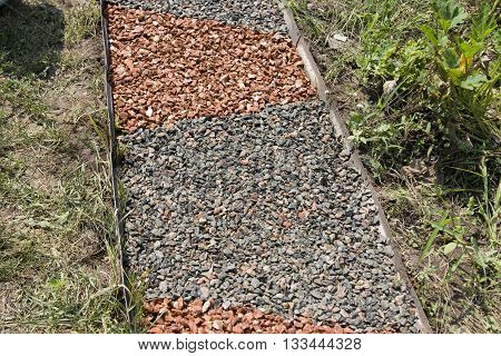Garden path paved with small stones from color