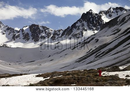 Hiker In Spring Snowy Mountains