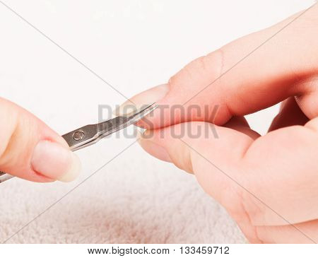 Woman making treatment of nail cuticle during manicure