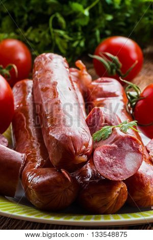 Smoked sausage and red ripe tomatoes on the kitchen table, selective focus