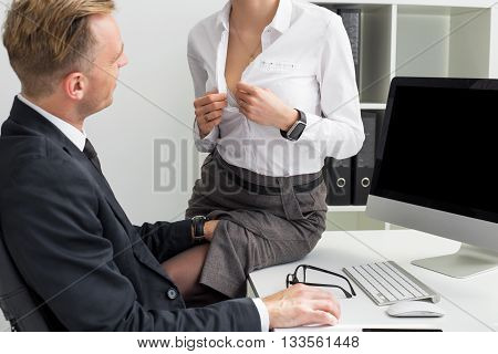 Secretary opening her blouse in front of her boss