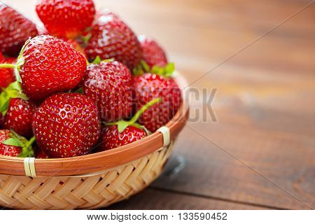 Very Beautiful Background With Fresh Strawberries In A Wicker Round Osier Basket On Old Brown Wooden