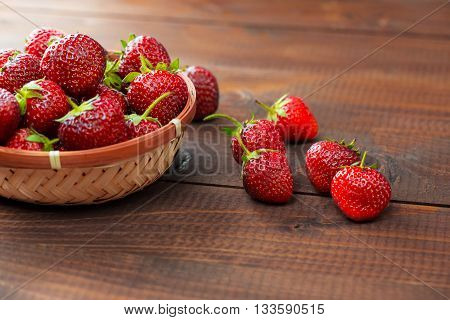 Very Beautiful Background With Fresh Strawberries In A Wicker Round Osier Basket On Old Brown Wooden