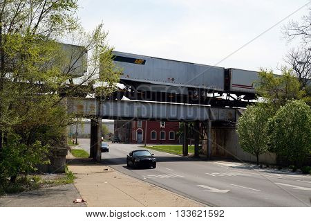 JOLIET, ILLINOIS / UNITED STATES - MAY 3, 2015: A freight train crosses a bridge over Ruby Street near downtown Joliet, Illinois.