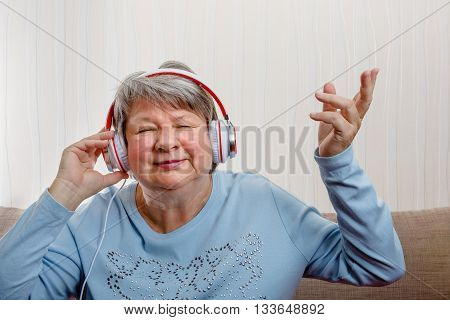 Senior with headphones enjoys music. She is having fun.