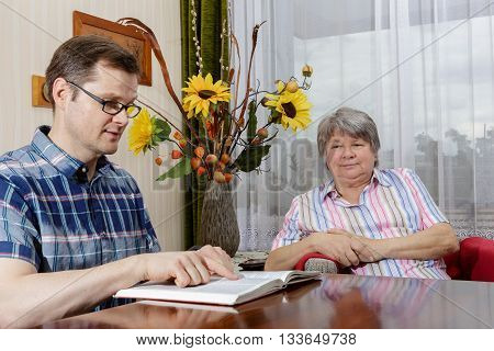 Nurse Reads A Book To A Senior