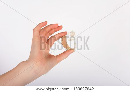 Woman hand showing a hearing aid with ear mould.