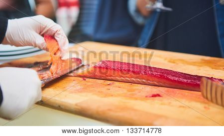 Professional chef cutting smoke salmon prepare for customer appetizer