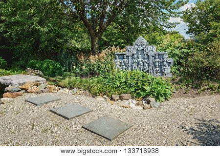 Appeltern, The Netherlands - July 22, 2015: The Gardens of Appeltern is the inspiration garden park in the Netherlands. In this picture a garden with a Buddhist scene in stone.
