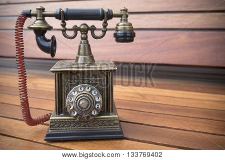 Retro Phone model vintage old dial Telephone on wood backgrond