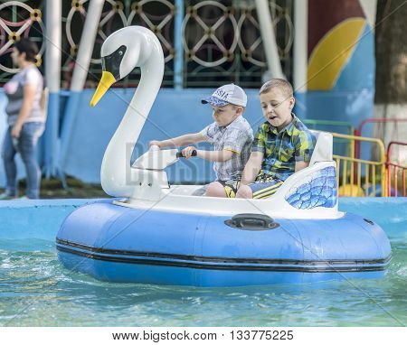 Rostov-on-Don Russia- May 29 2016: Two cheerful boy manage boat- swan in the park named after Ostrovsky