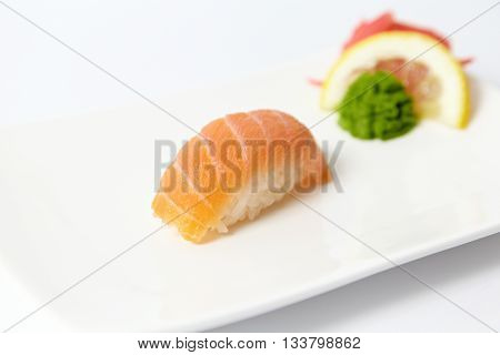 Salmon sushi with lemon, ginger and wasabi