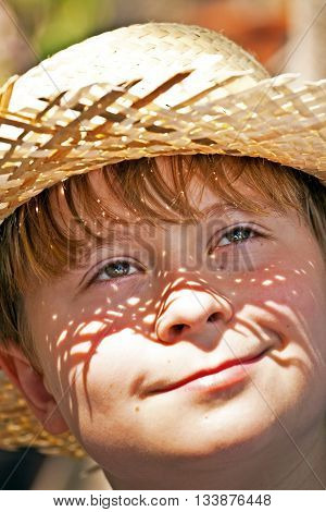 Young Boy With Straw Hat Is Happy And Smiles