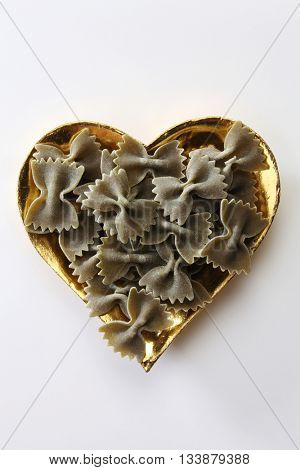 farfalle or farfalloni dry pasta on the heart shape container