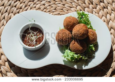 Closeup Of White Plate With Spanish Croquettes With Veal Meat And Mushrooms Served With Salad And Sa