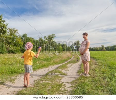 小男孩制作肥皂泡沫与他肚子的母亲