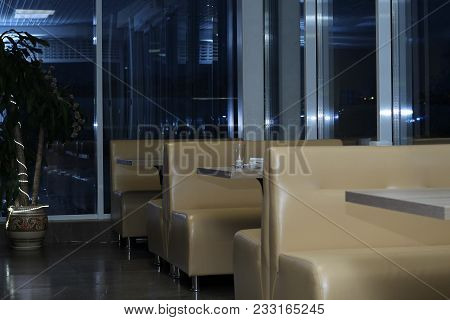 Interior Of The Cafe. Empty Sofas Near Windows In The Evening