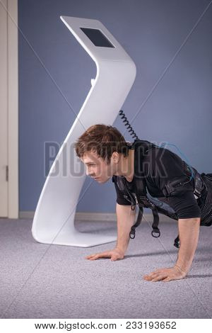 Man In Ems Suits Doing Plank Exercise. Workout.