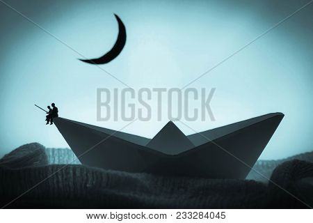 Father And Son Fishing At Night On A Boat
