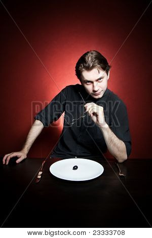 Funny young man eating grape