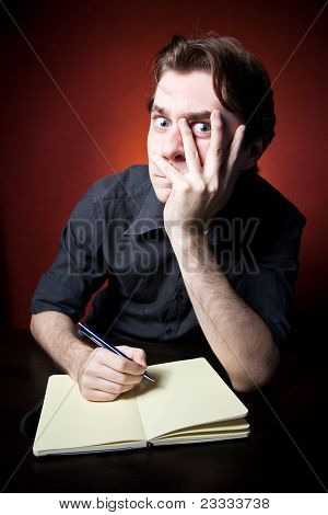 In Search Of Inspiration. A man with an empty notebook