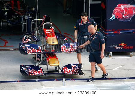 SEPANG, Malasia - el 8 de abril: Scuderia Toro Rosso equipo mecánica Inspeccione la nariz y las alas de su 